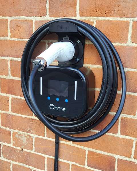 Ohme EV charger installed on a brick wall